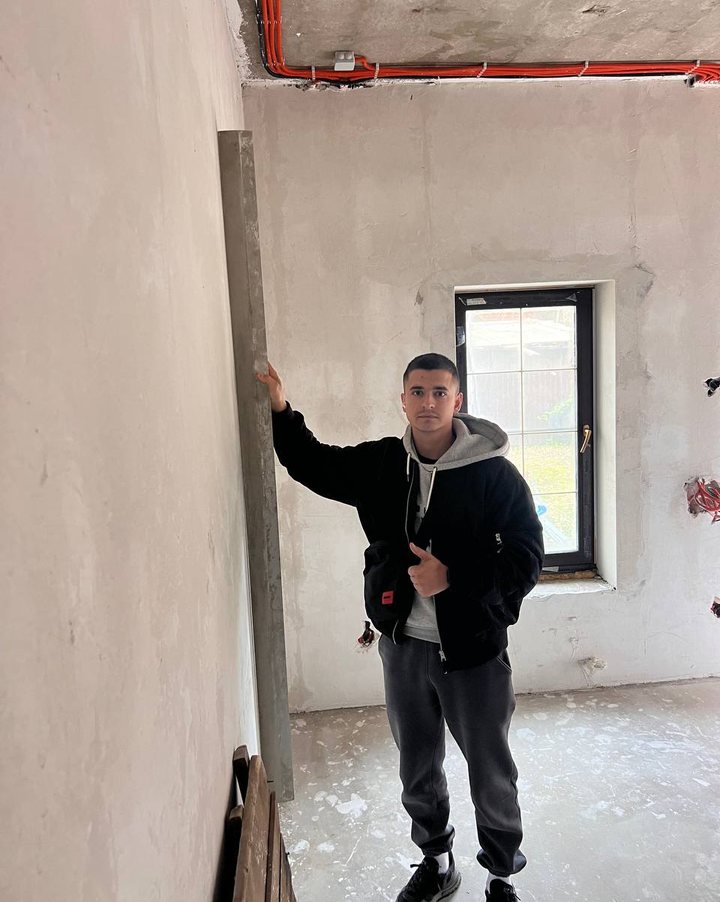 Сергей на объекте проверяет стену двухметровым правилом